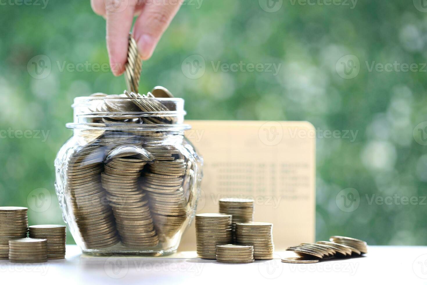 finanza, donna mano mettendo un' moneta in bicchiere bottiglia su natura verde sfondo, affari investimento e Salva i soldi per preparare nel futuro concetto foto