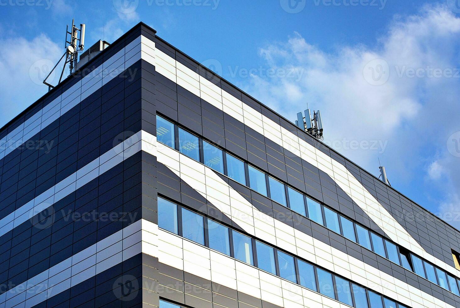 astratto avvicinamento di il rivestito di vetro facciata di un' moderno edificio coperto nel riflessivo piatto bicchiere. architettura astratto sfondo. bicchiere parete e facciata dettaglio. foto