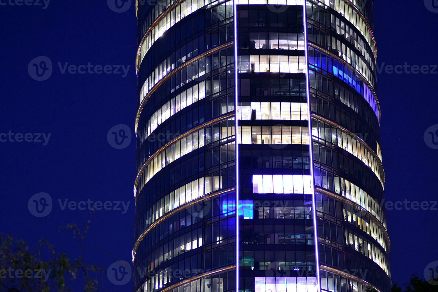 Visualizza di a notte bicchiere edifici e moderno attività commerciale grattacieli. Visualizza di moderno grattacieli e attività commerciale edifici nel centro. grande città a notte. foto