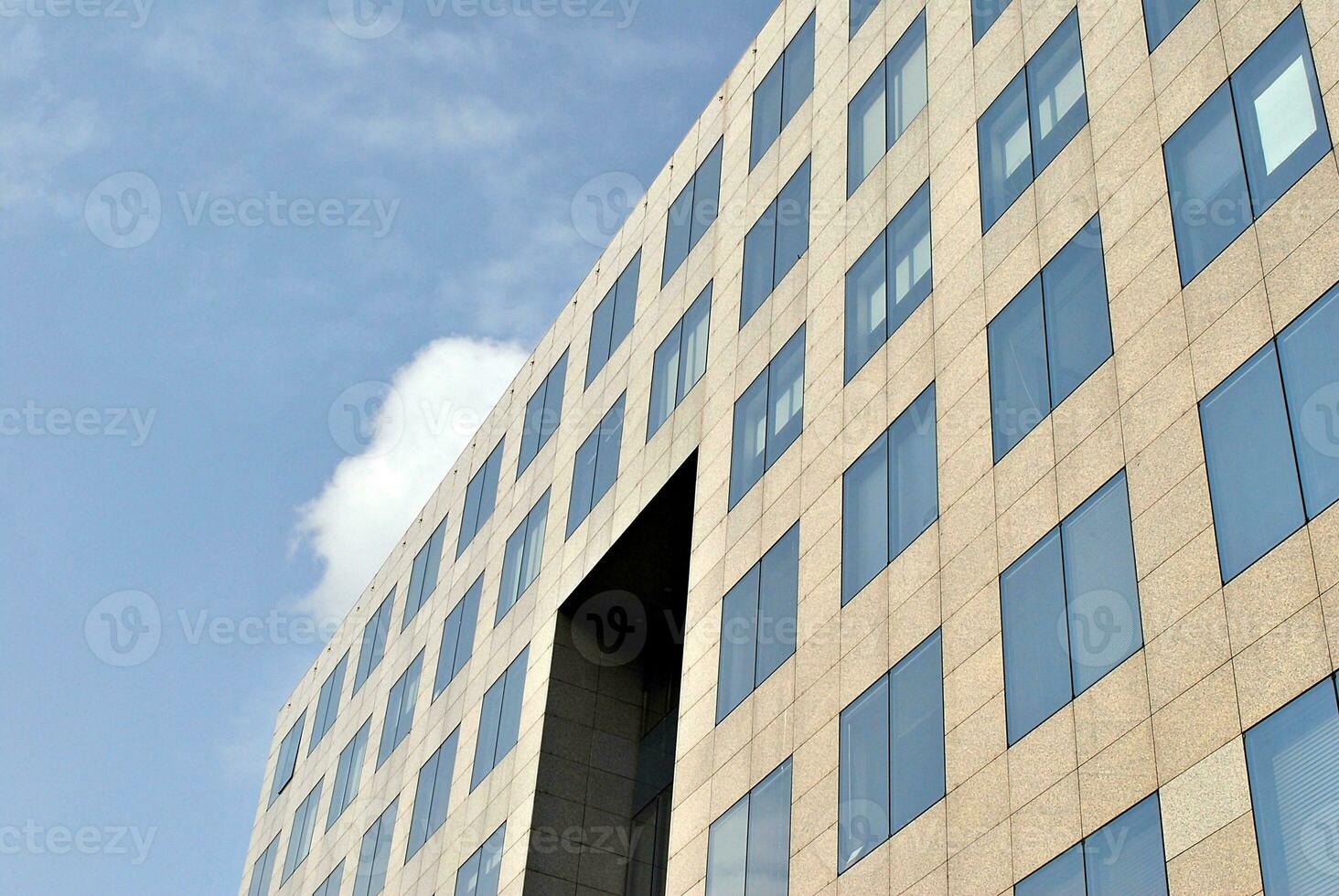 astratto avvicinamento di il rivestito di vetro facciata di un' moderno edificio coperto nel riflessivo piatto bicchiere. architettura astratto sfondo. bicchiere parete e facciata dettaglio. foto