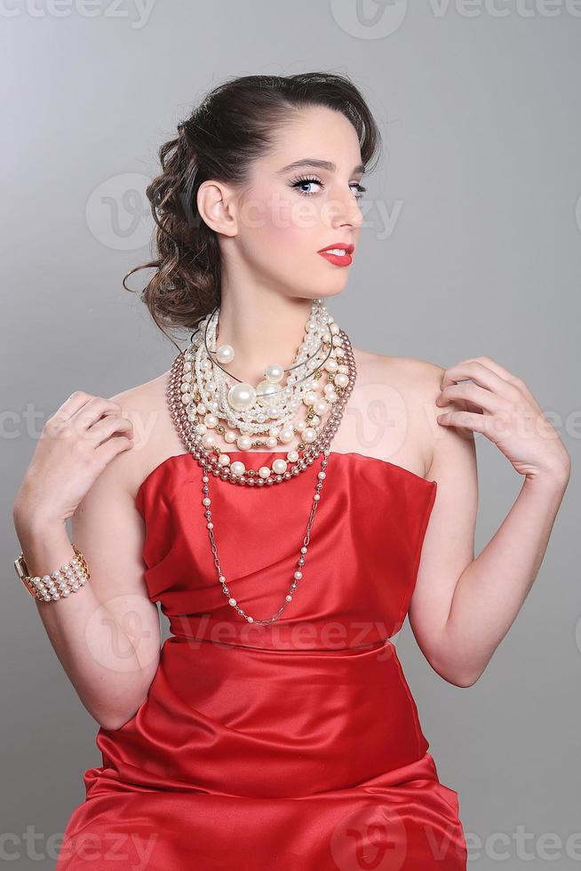 bella modella a tema rosso che indossa un sacco di perle foto