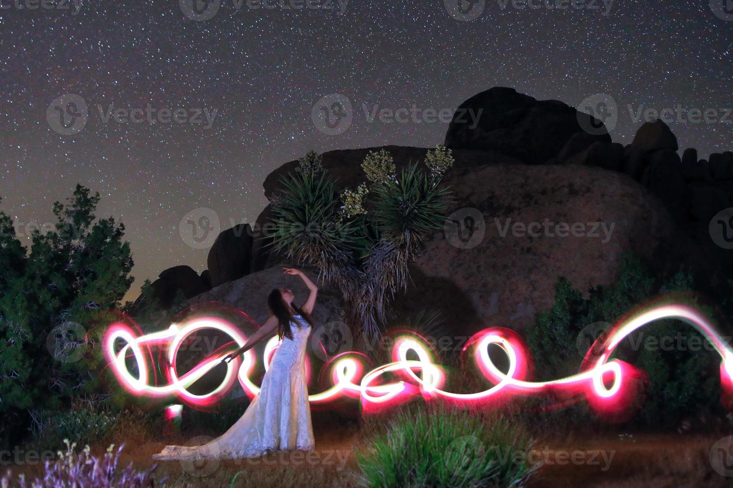 persona dipinta di luce nel deserto sotto il cielo notturno foto