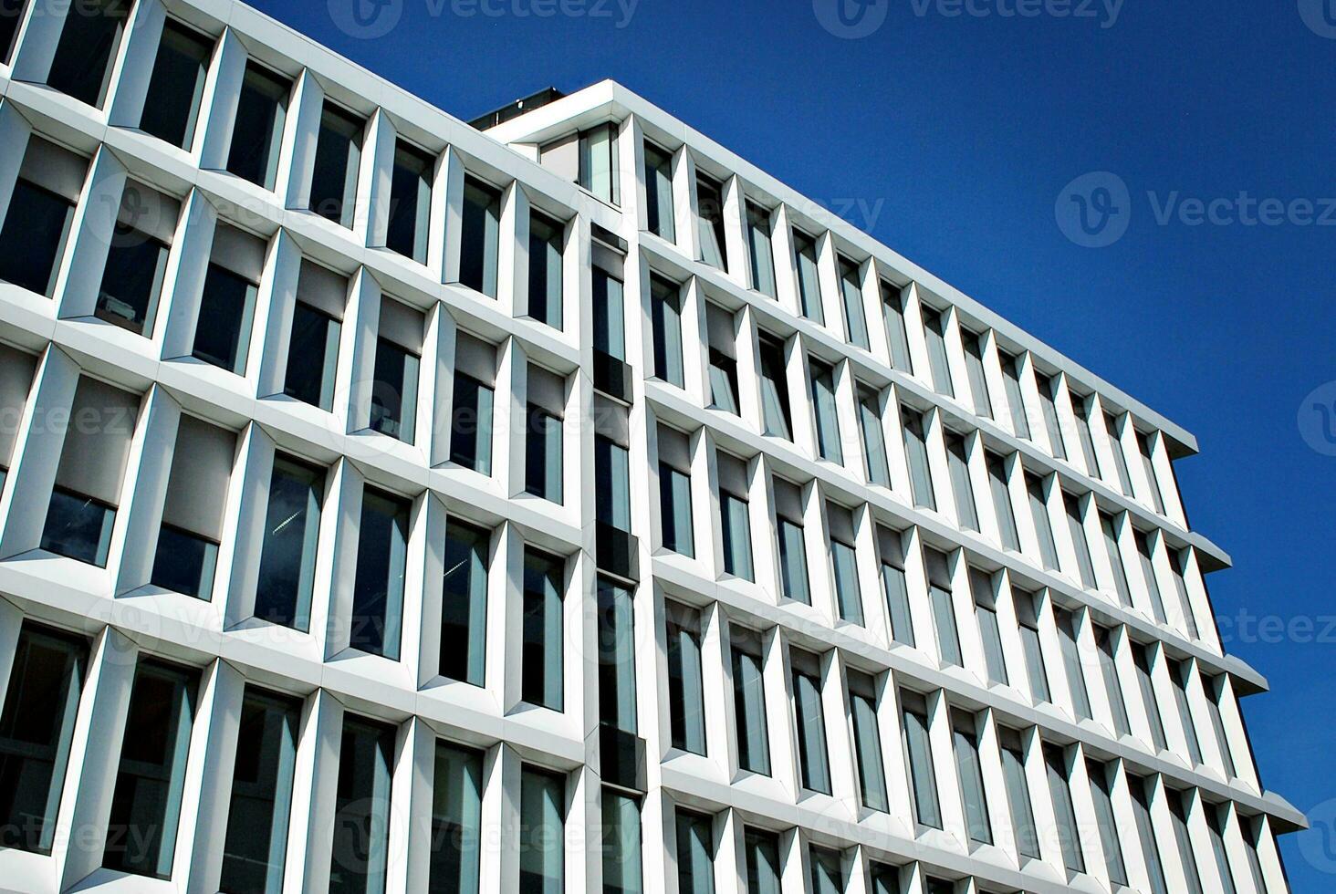 astratto avvicinamento di il rivestito di vetro facciata di un' moderno edificio coperto nel riflessivo piatto bicchiere. architettura astratto sfondo. bicchiere parete e facciata dettaglio. foto