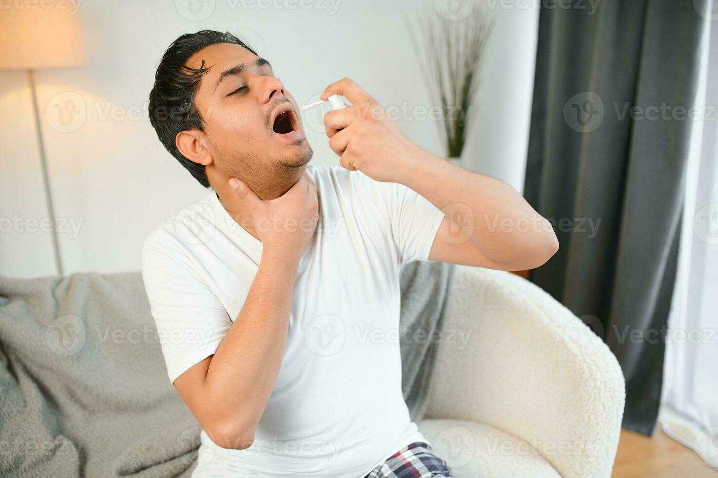 indiano uomo malato a casa, freddo, influenza. un' uomo usi un' gola spray foto