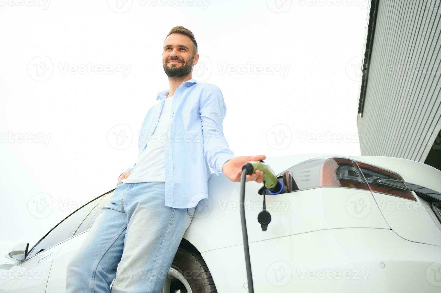 uomo in piedi di il suo elettrico auto foto