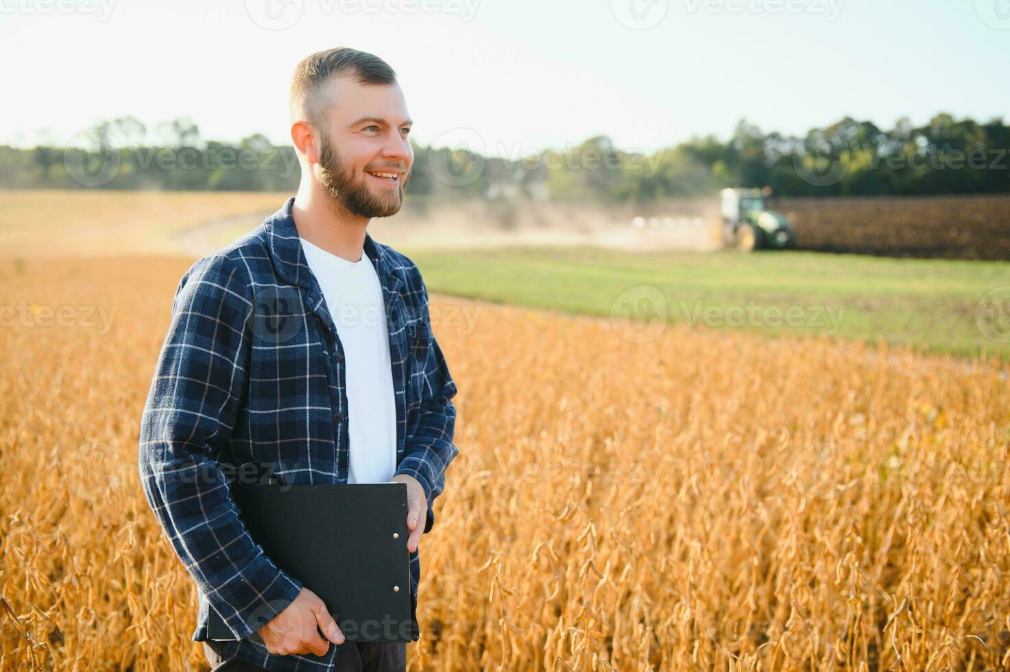 agronomo ispezionando soia fagiolo colture in crescita nel il azienda agricola campo. agricoltura produzione concetto. giovane agronomo esamina soia Ritaglia su campo. contadino su soia campo. foto