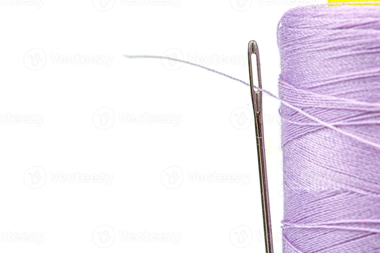 macro matassa di filo viola colori con un' ago su un' bianca sfondo foto