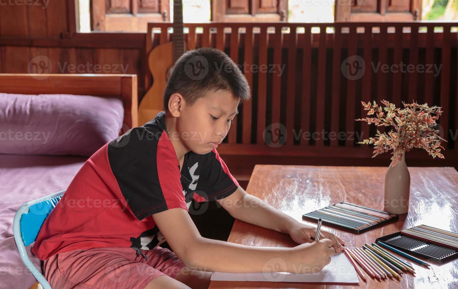 un ragazzo seduto a casa sua a disegnare e dipingere. foto