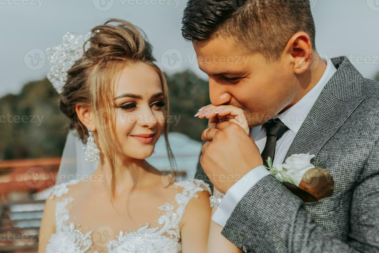 il sposa e sposo contro il sfondo di il cielo. reale nozze concetto. il sposo baci il della sposa mano. tenerezza e calma. ritratto fotografia foto