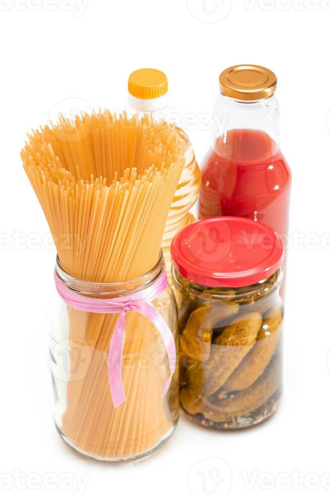 cibo riserve. in scatola cibo, spaghetti, sottaceti e pomodoro succo - isolato su bianca sfondo. emergenza cibo Conservazione nel Astuccio di crisi. strategico cibo forniture - solitudine foto