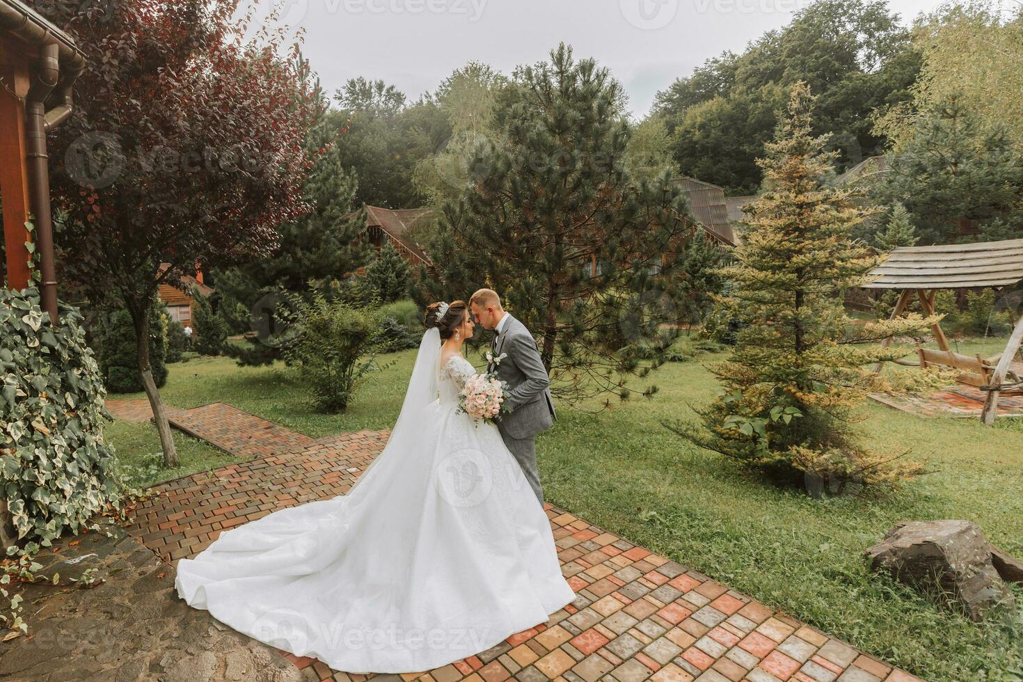 bello sposo e affascinante sposa insieme nel il parco. ritratto. lussuoso vestito con un' lungo treno. elegante giovane sposo. nozze mazzo. lusso nozze posto per firma foto