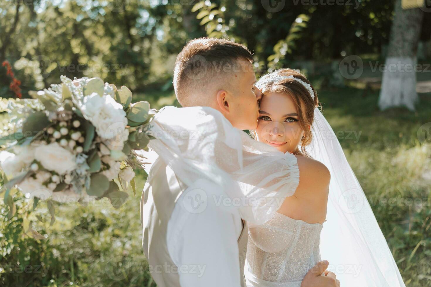 ritratto di un' bellissimo coppia nel amore su il tuo nozze giorno. un' camminare nel il parco nel il luce del sole e verde. sorprendente baci e abbracci di il sposa e sposo con un' mazzo foto