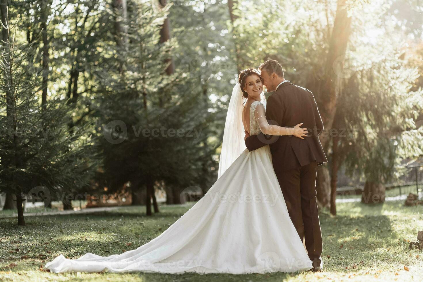 romantico fiaba sposini coppia abbraccio e bacio nel foresta a tramonto foto