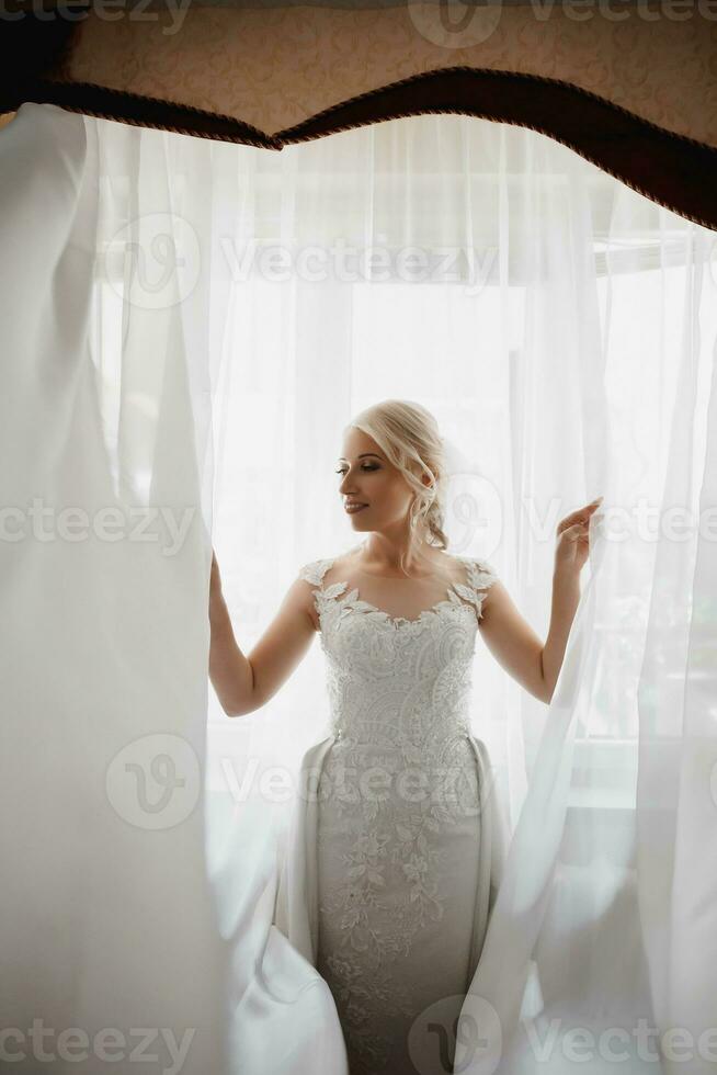 bella sposa ritratto matrimonio trucco acconciatura, splendida giovane donna in abito bianco a casa. serie. foto