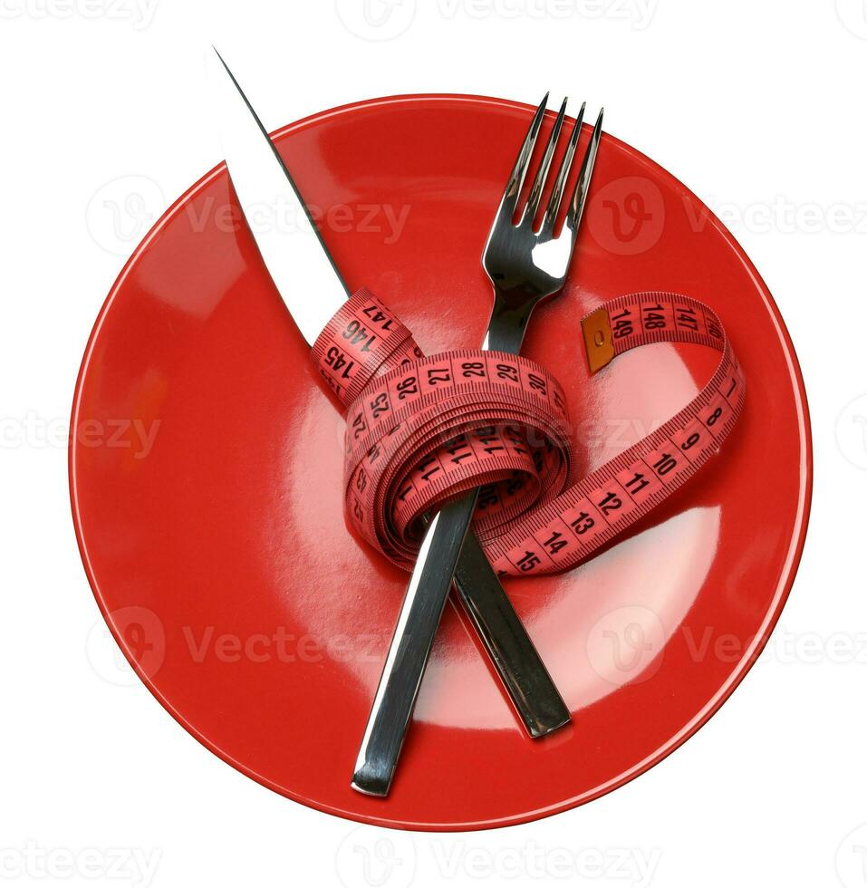 rosso il giro piatto e forchetta e coltello avvolto nel verde misurazione nastro foto
