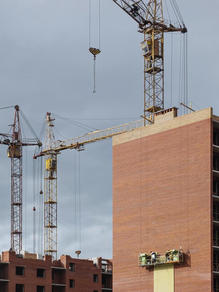 gru gialle sullo sfondo di edifici in costruzione foto