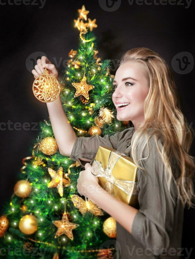 contento ragazza decorazione Natale albero foto