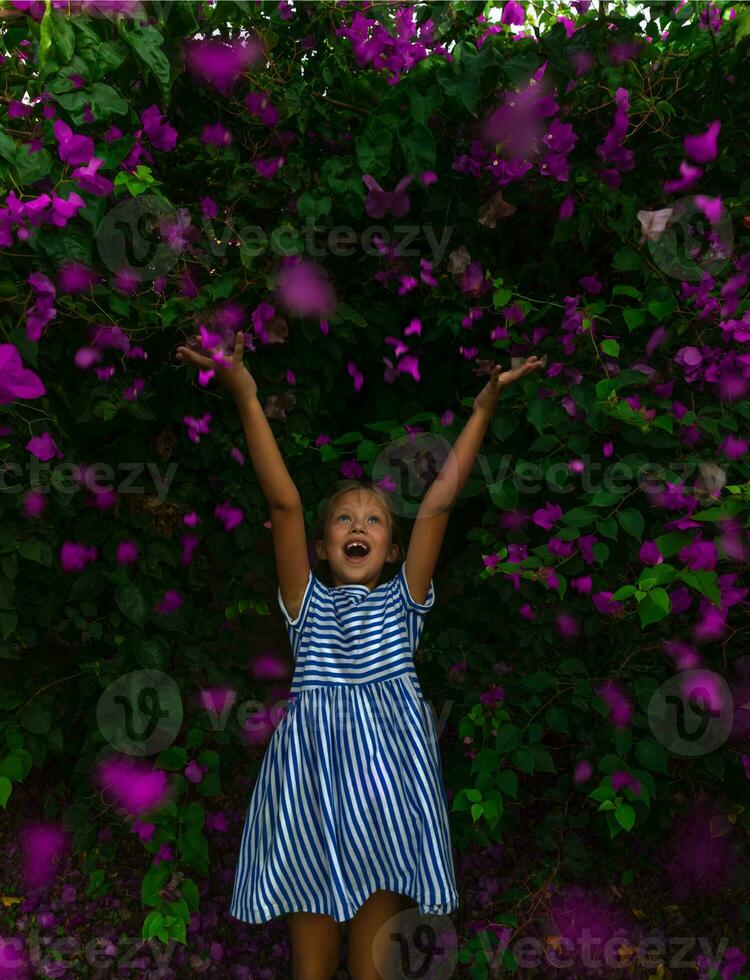 contento poco ragazza nel fiori giardino foto