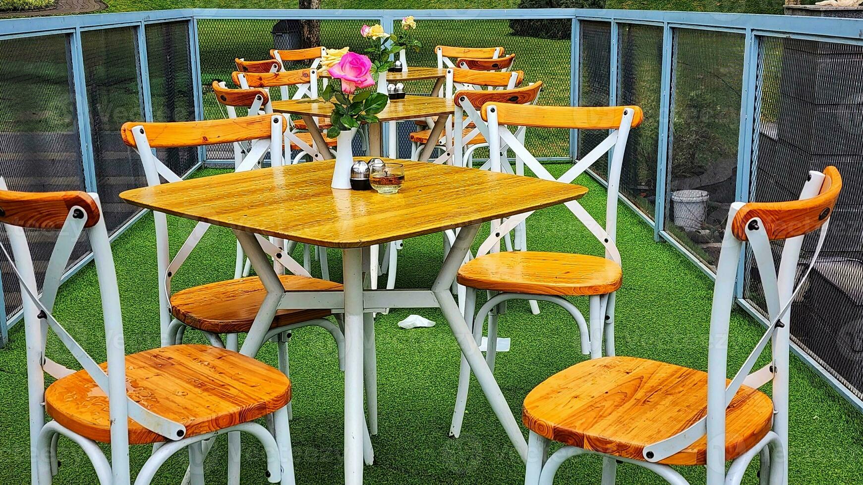 di legno tavolo e sedie nel un' estate bar su il verde erba foto