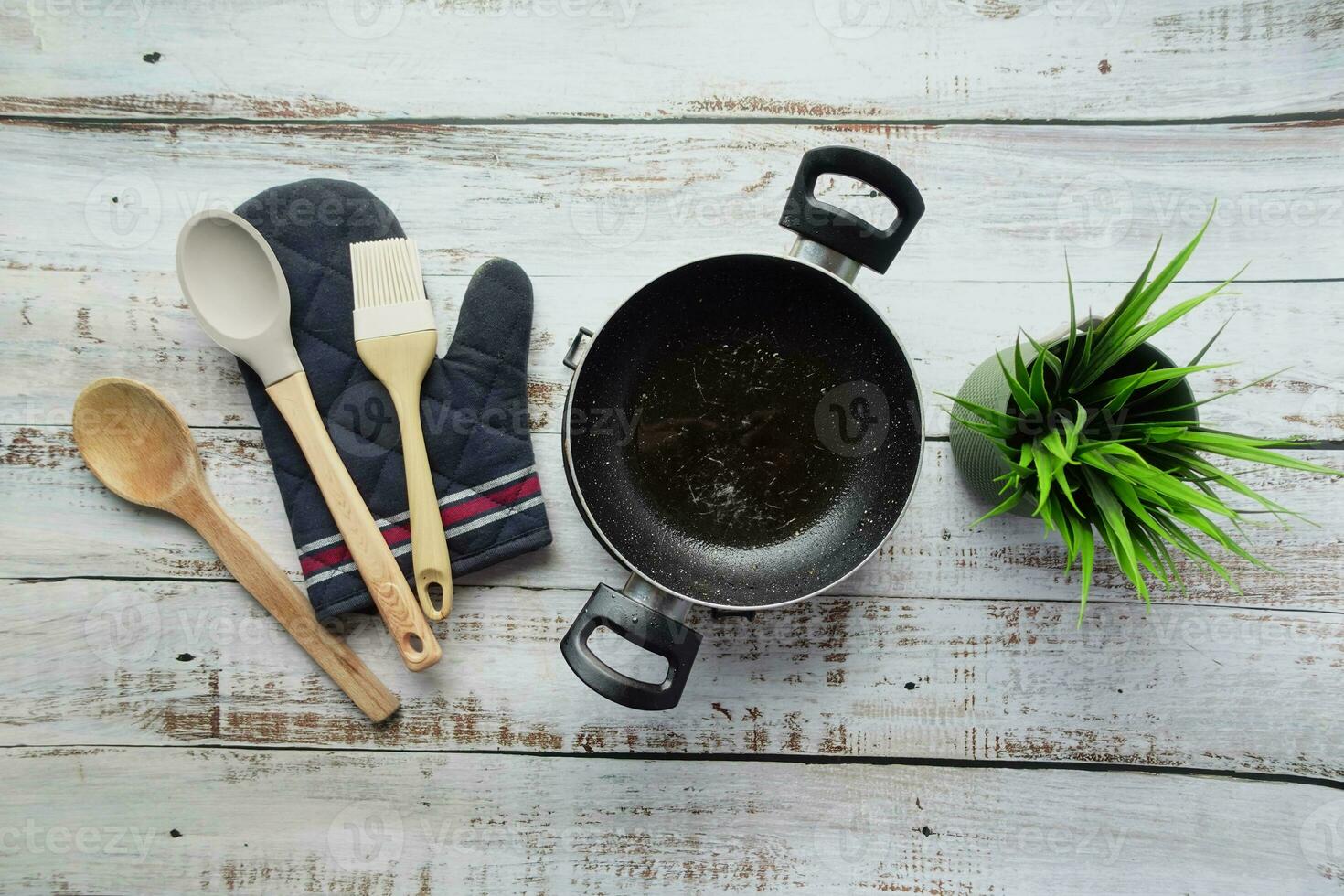 superiore Visualizza di nero frittura padella e cucinando cucchiaio su tavolo foto