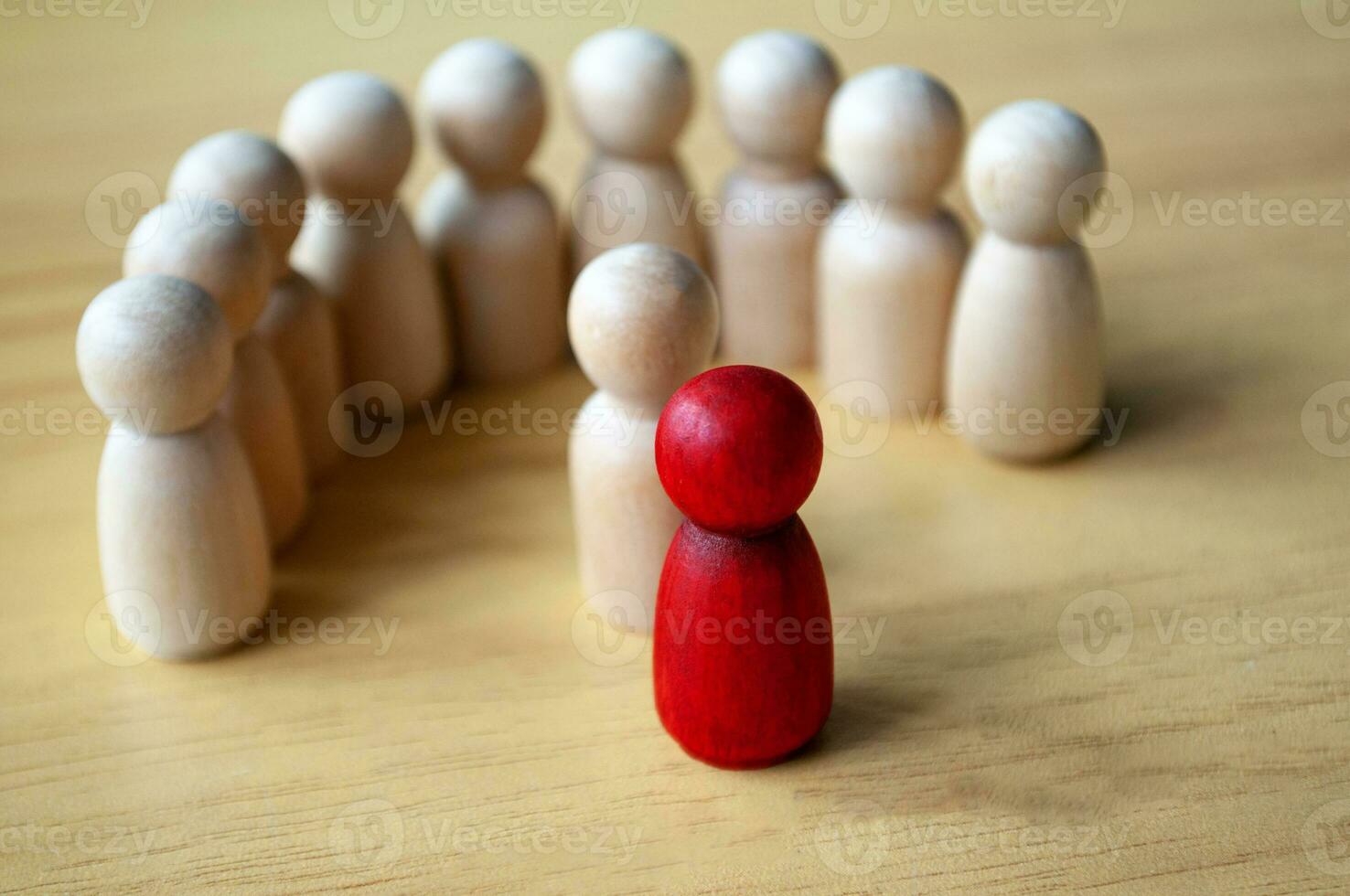 rosso di legno Bambola circondato con altro bambole. che rappresentano o comando o molestie. foto