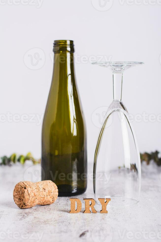 sobrio gennaio concetto, testo, bicchiere, bottiglia e sughero su il tavolo verticale Visualizza foto