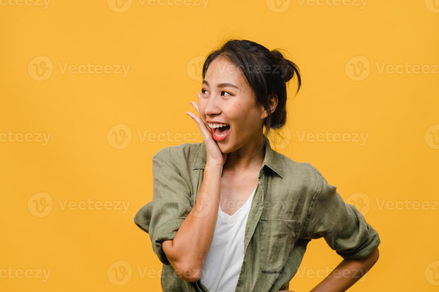 la giovane donna asiatica si sente felice con l'espressione positiva, gioiosa sorpresa funky, vestita con un panno casual isolato su sfondo giallo. felice adorabile donna felice esulta successo. espressione facciale. foto