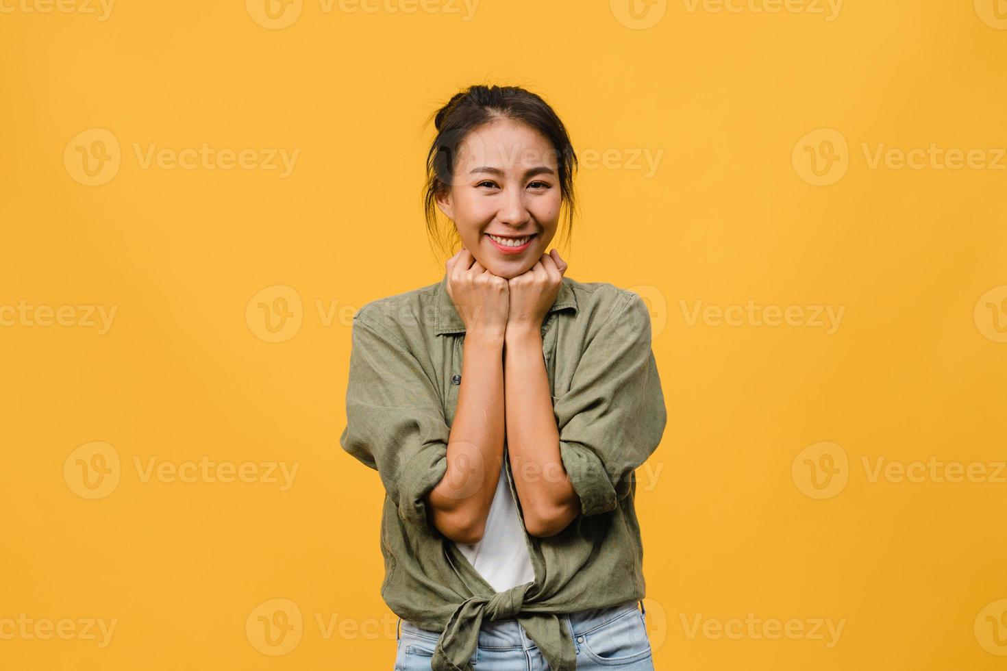 giovane donna asiatica con espressione positiva, sorriso ampiamente, vestita con abiti casual e guardando la telecamera su sfondo giallo. felice adorabile donna felice esulta successo. concetto di espressione facciale. foto