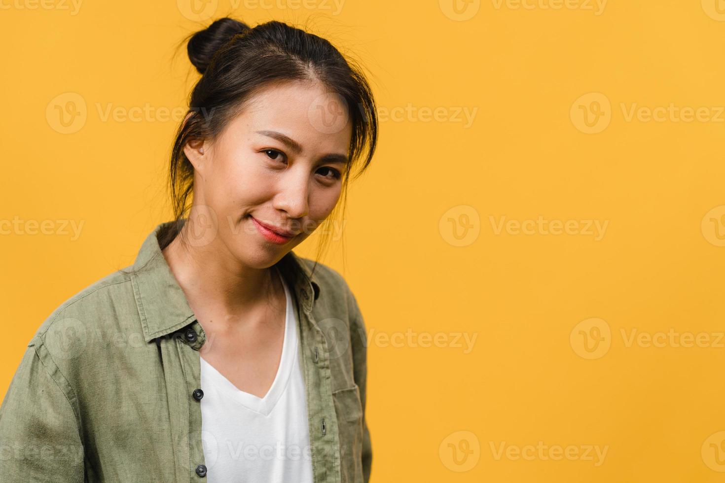 giovane donna asiatica con espressione positiva, sorriso ampiamente, vestita con abiti casual e guardando la telecamera su sfondo giallo. felice adorabile donna felice esulta successo. concetto di espressione facciale. foto