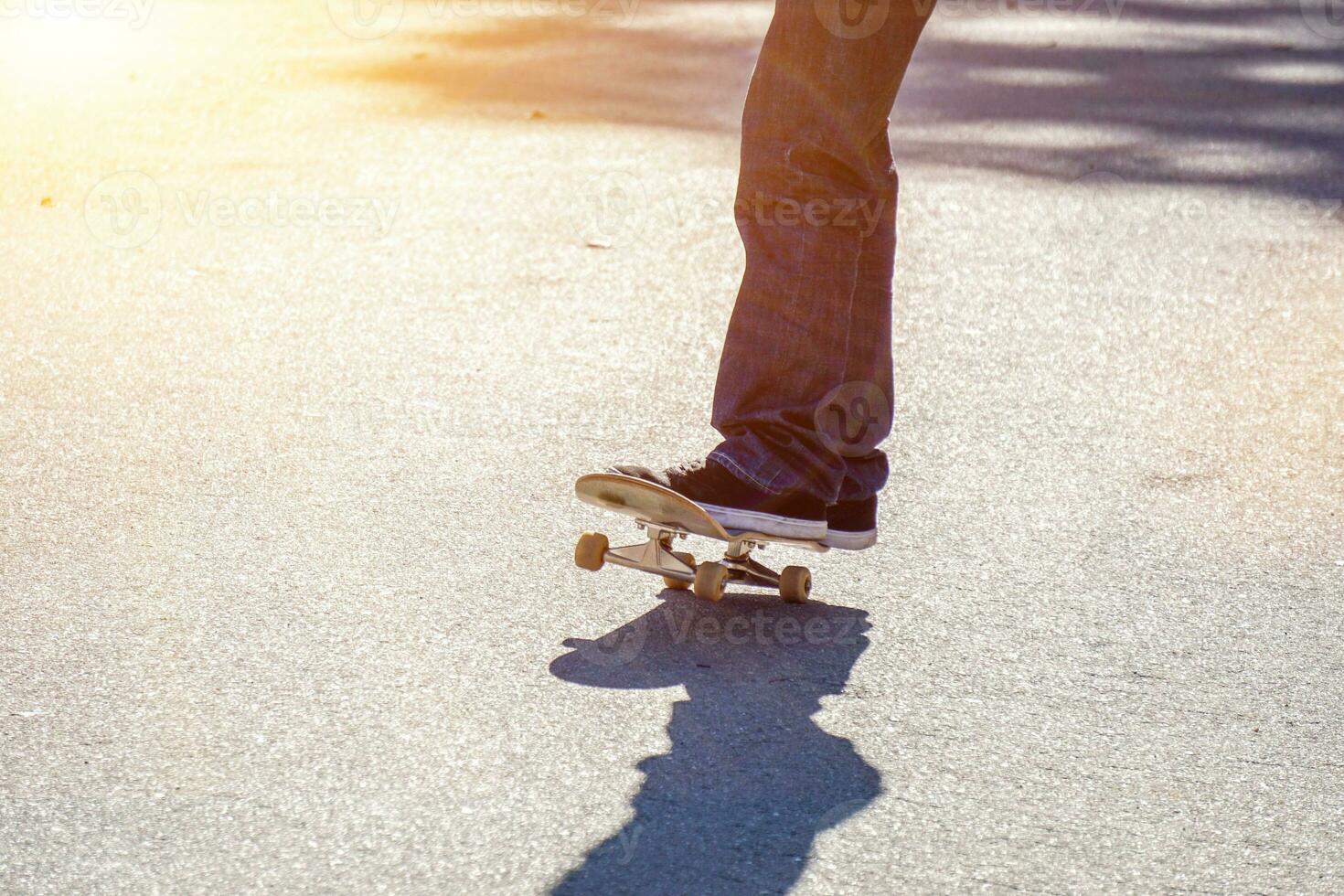 avvicinamento gambe di adolescente giocando un' skateboard su pubblico del parco strada. foto