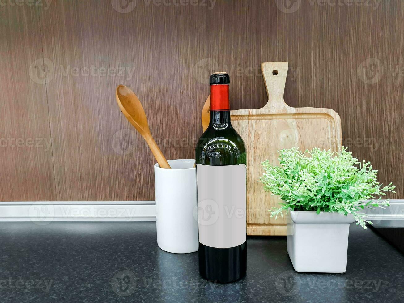 di legno utensili da cucina e bottiglia di vino con decorare piccolo verde pianta nel bianca ceramica vaso su cucina scaffali e di legno parete sfondo. foto