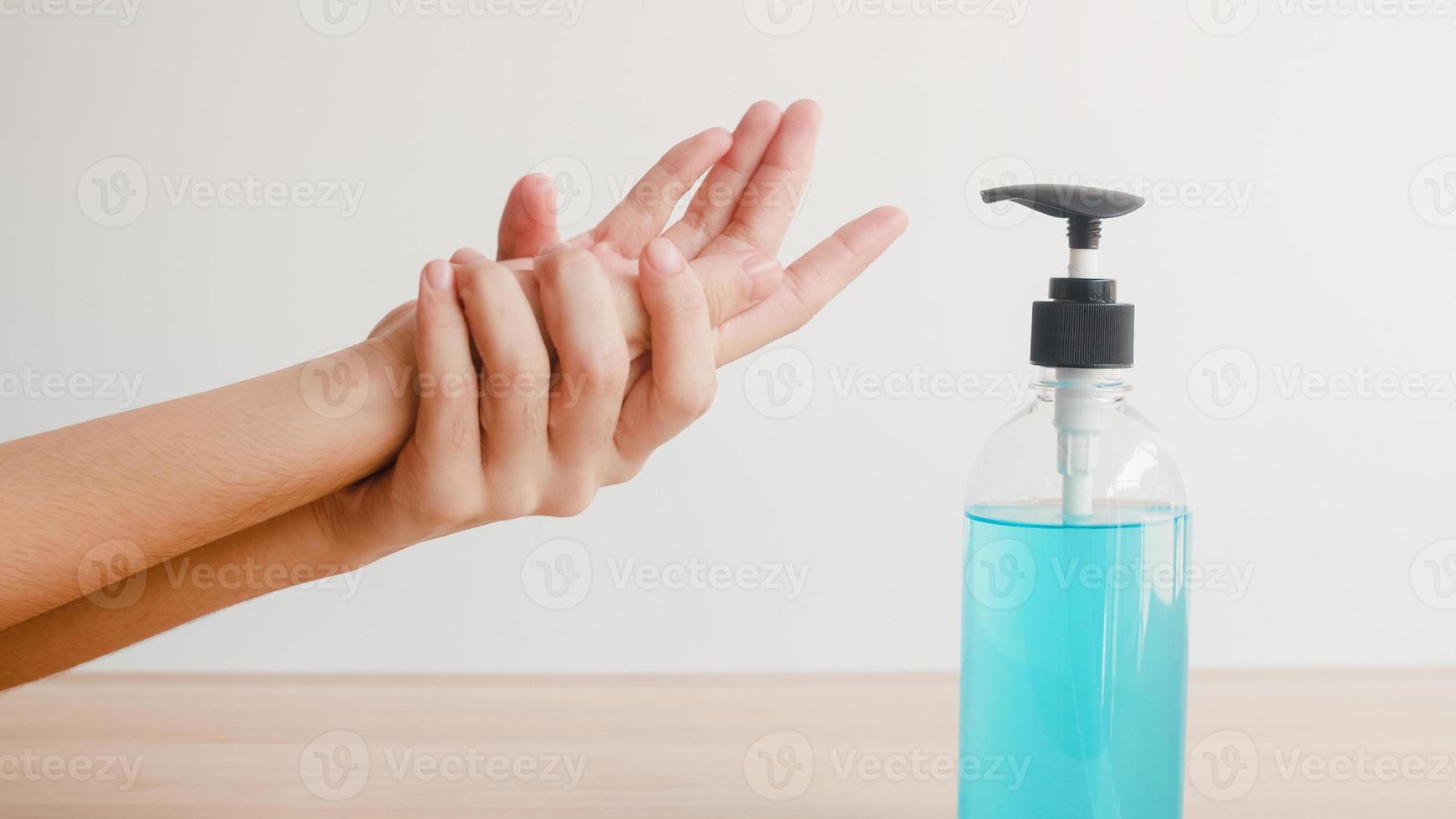 donna asiatica che usa disinfettante per le mani in gel alcolico per lavare le mani per proteggere il coronavirus. la femmina spinge la bottiglia di alcol per pulire la mano per l'igiene quando il distanziamento sociale rimane a casa e il tempo di autoquarantena. foto