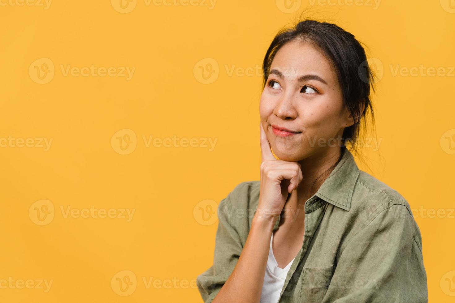 ritratto di giovane donna asiatica con espressione positiva, sorriso ampiamente, vestita con abiti casual su sfondo giallo. felice adorabile donna felice esulta successo. concetto di espressione facciale. foto