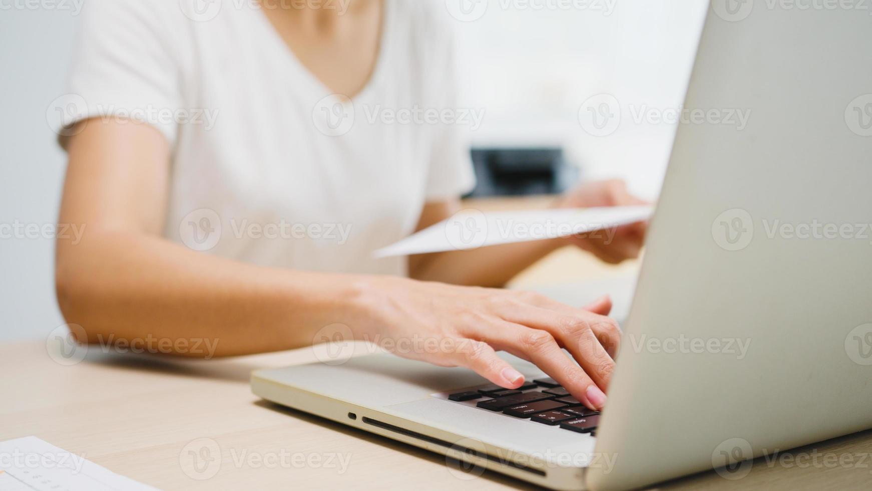 freelance giovane donna d'affari asia abbigliamento casual utilizzando laptop che lavora nel soggiorno di casa. lavoro da casa, lavoro a distanza, autoisolamento, distanziamento sociale, quarantena per la prevenzione del virus corona. foto