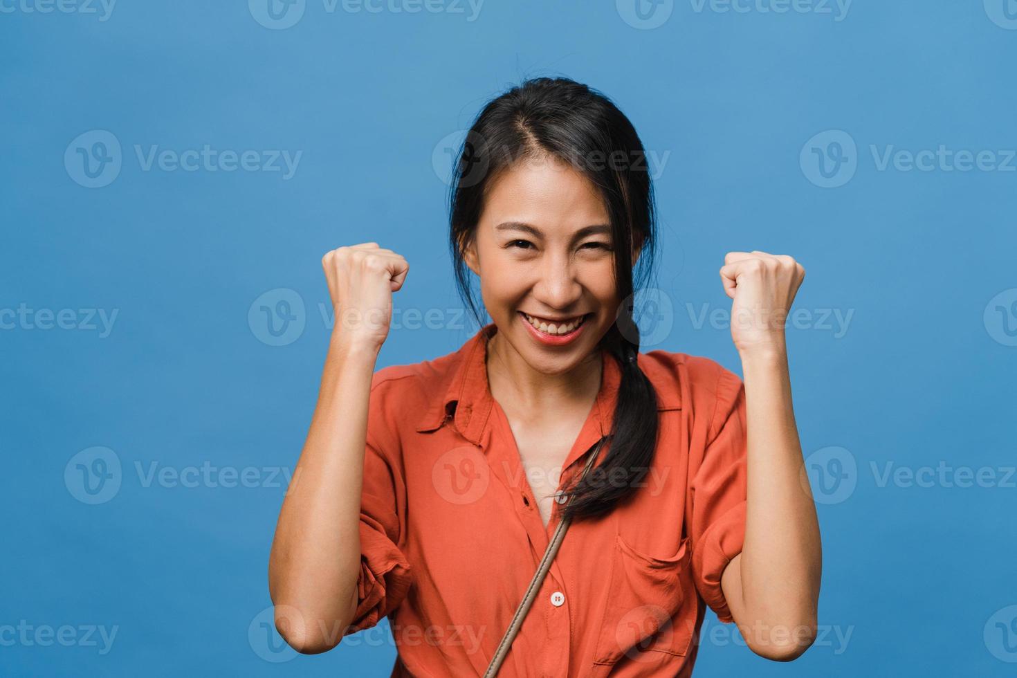 giovane donna asiatica con espressione positiva, gioiosa ed eccitante, vestita con abiti casual e guarda la telecamera su sfondo blu. felice adorabile donna felice esulta successo. concetto di espressione facciale. foto