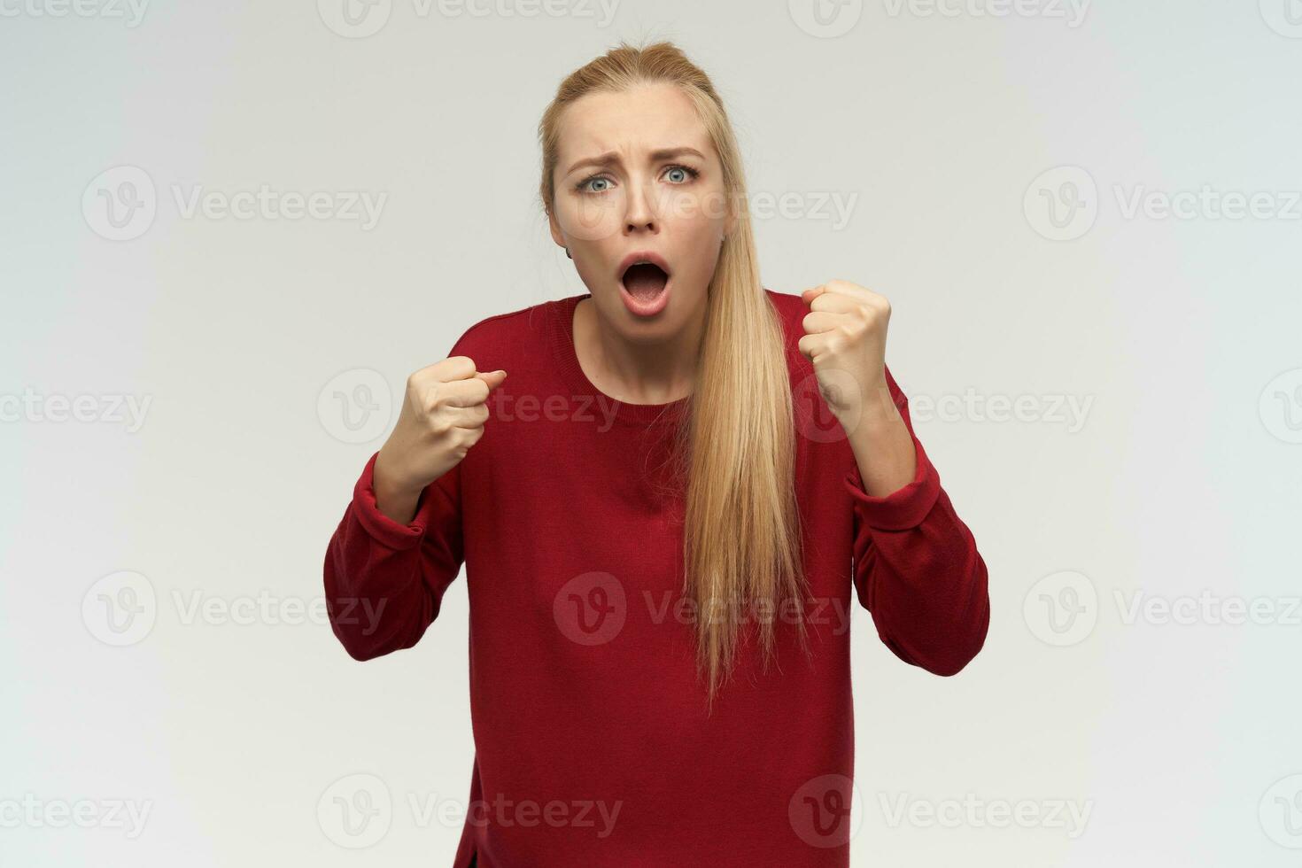 simpatico guardare donna, bellissimo ragazza con lungo biondo capelli. indossare rosso maglione. persone e emozione concetto. Guardando a il telecamera, isolato al di sopra di bianca sfondo foto