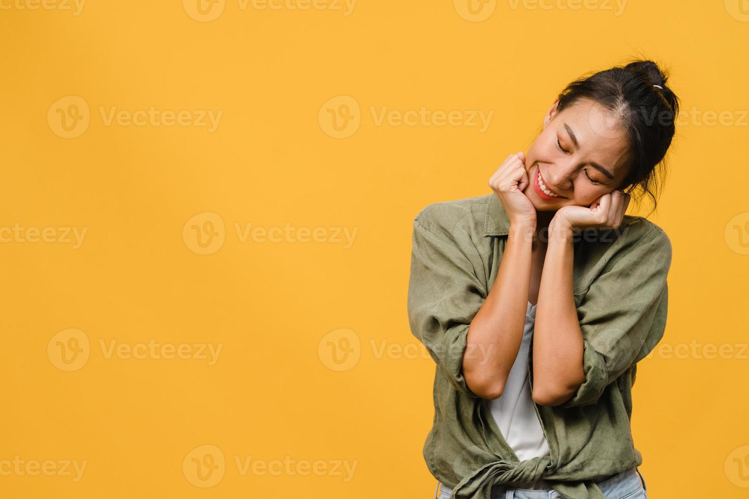 ritratto di giovane donna asiatica con espressione positiva, sorriso ampiamente, vestita con abiti casual su sfondo giallo. felice adorabile donna felice esulta successo. concetto di espressione facciale. foto