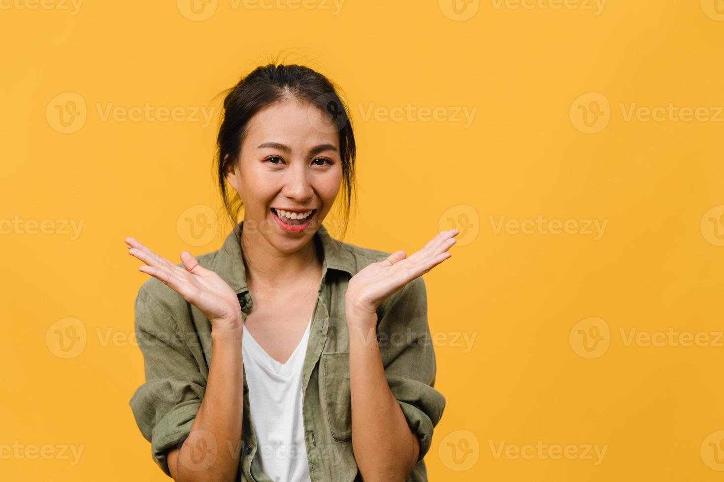 giovane donna asiatica con espressione positiva, sorriso ampiamente, vestita con abiti casual e guardando la telecamera su sfondo giallo. felice adorabile donna felice esulta successo. concetto di espressione facciale. foto