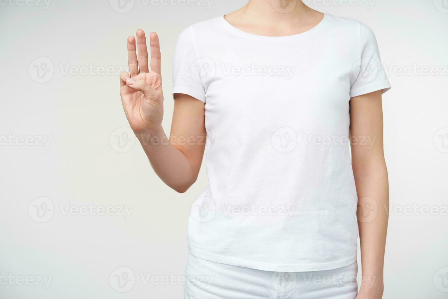 studio foto di giovane donna conservazione mano sollevato e formatura lettera w mentre in piedi al di sopra di bianca sfondo. cartello linguaggio e umano mani concetto