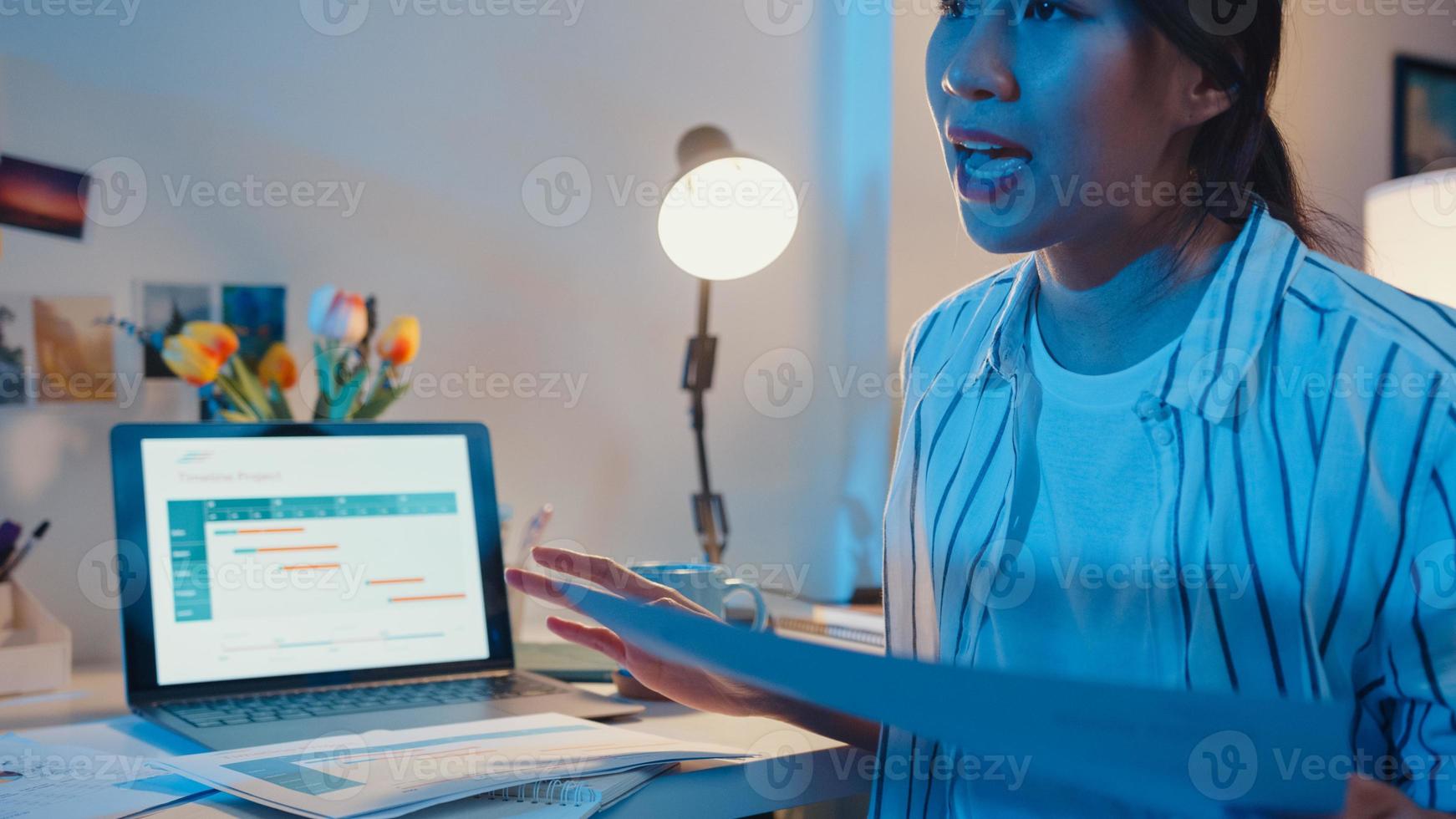 giovane imprenditrice asiatica prepara la presentazione prima dell'intervista della conferenza a casa. lavoro da sovraccarico domestico di notte, da remoto, distanza sociale, quarantena per la prevenzione del virus corona. foto