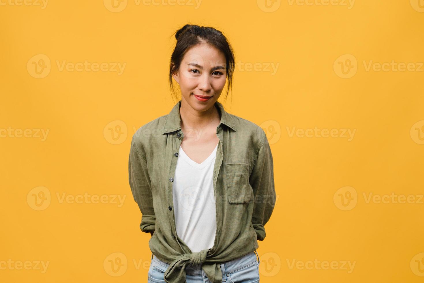 giovane donna asiatica con espressione positiva, sorriso ampiamente, vestita con abiti casual e guardando la telecamera su sfondo giallo. felice adorabile donna felice esulta successo. concetto di espressione facciale. foto