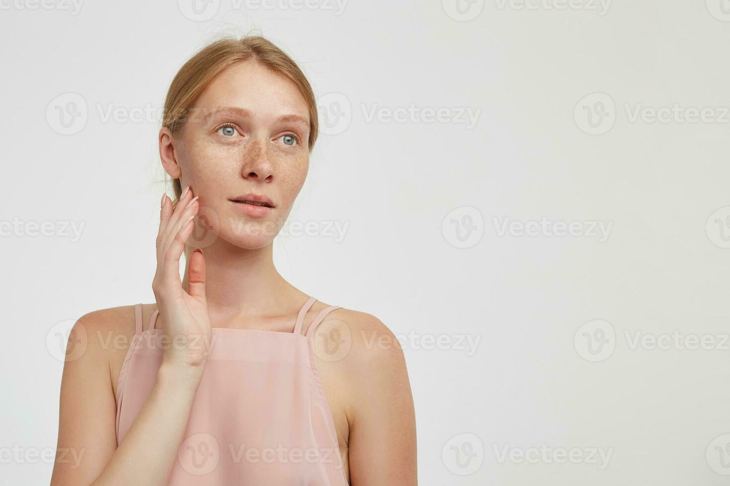 interno foto di giovane affascinante testa Rossa donna vestito nel casuale indossare toccante delicatamente sua viso con sollevato mano e guardare pensieroso a parte, isolato al di sopra di bianca sfondo