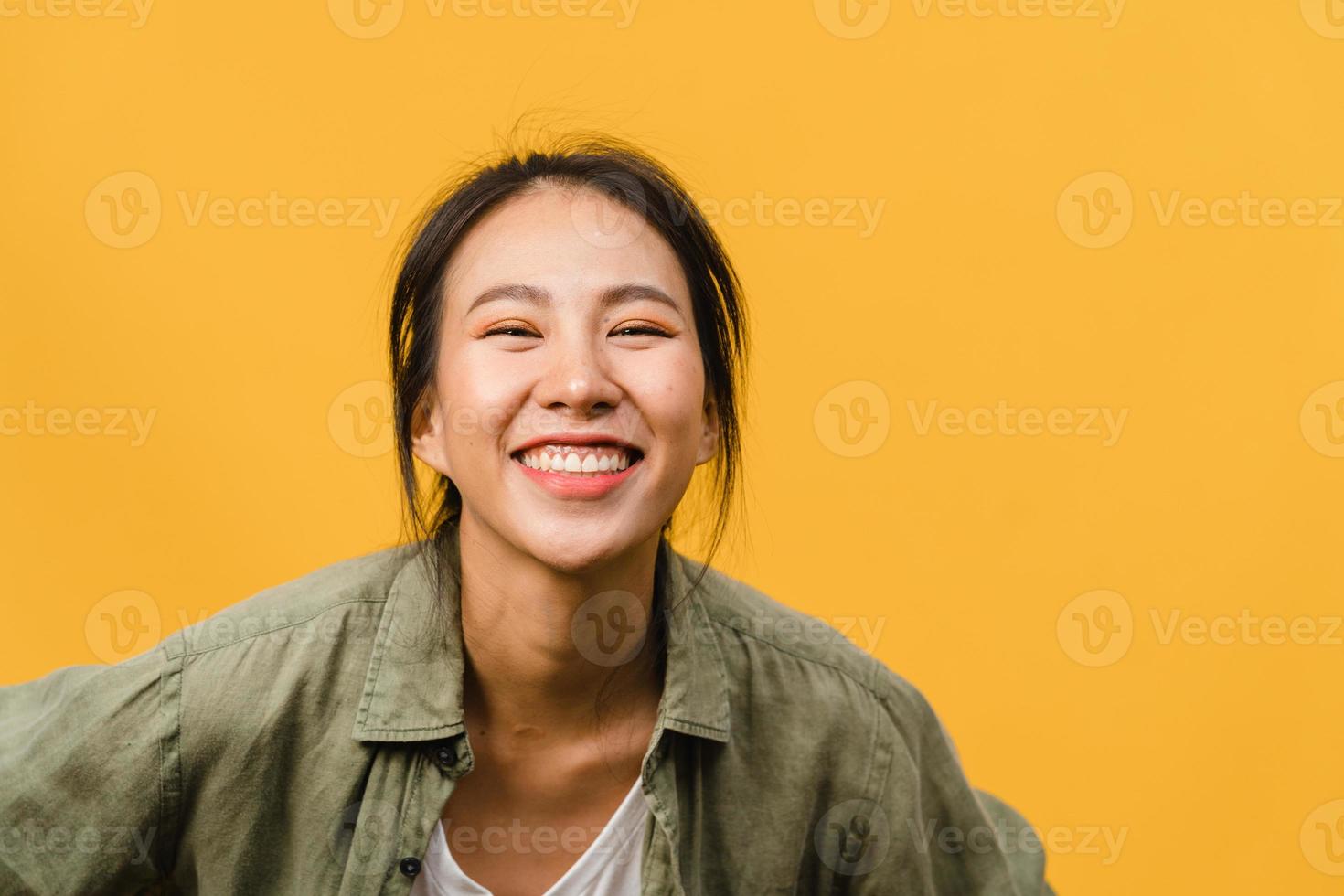 giovane donna asiatica con espressione positiva, sorriso ampiamente, vestita con abiti casual e guardando la telecamera su sfondo giallo. felice adorabile donna felice esulta successo. concetto di espressione facciale. foto