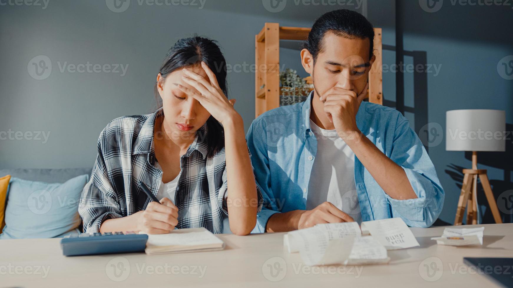 stress asia coppia uomo e donna usa la calcolatrice per calcolare il budget familiare, i debiti, le spese mensili durante la crisi economica finanziaria a casa. problemi di denaro del matrimonio, concetto di pianificazione del bilancio familiare. foto