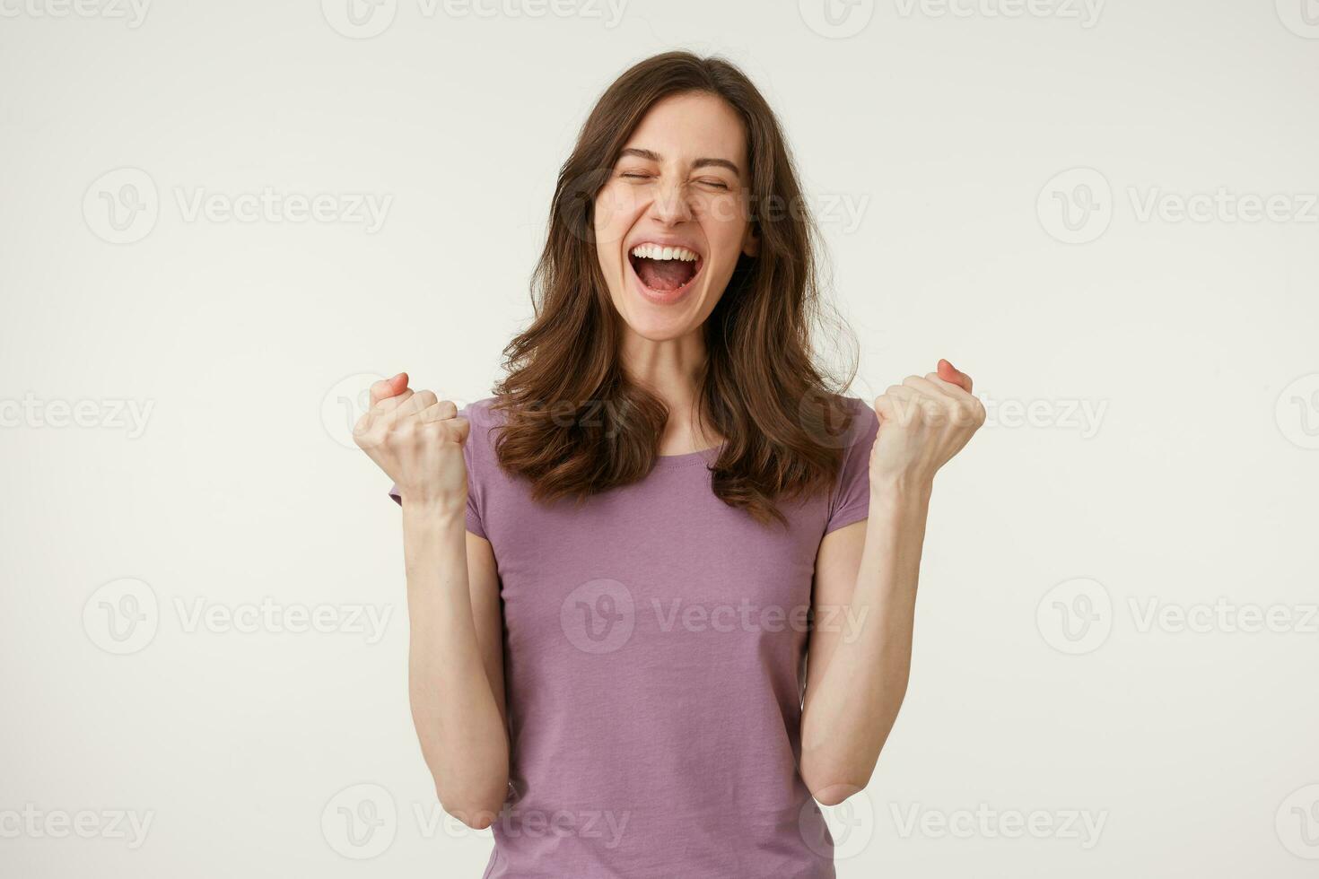 contento ragazza festeggiare vittoria. giovane donna contento sorridente raccolta sua pugni su, raffigura un' gesto di successo, rottura attraverso per raggiungere un' obiettivo, isolato su bianca sfondo foto