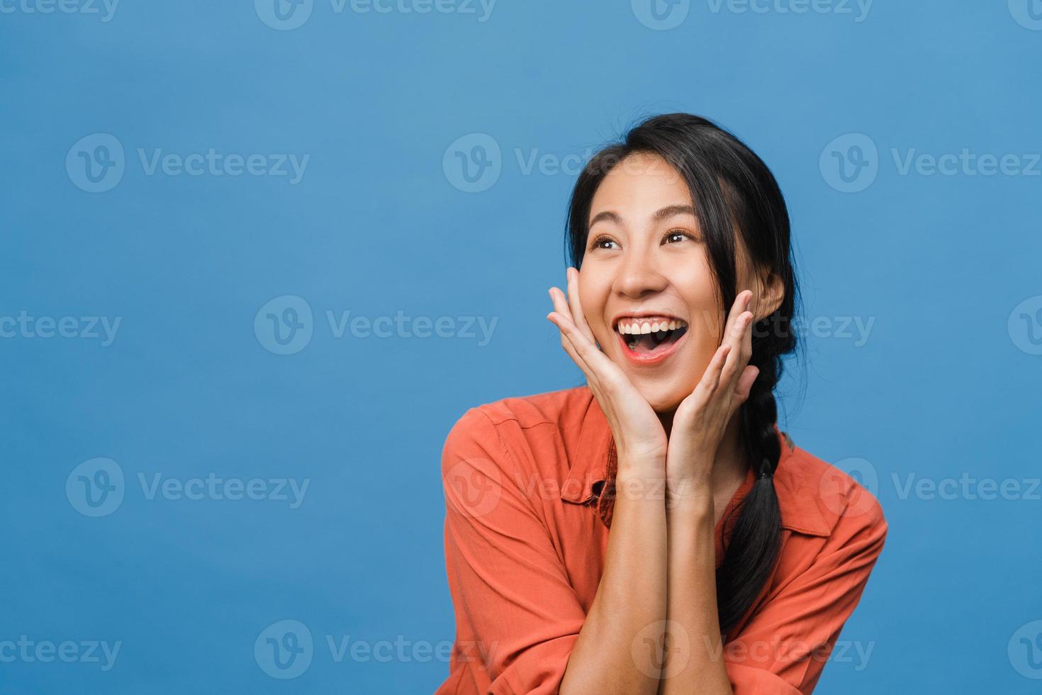 la giovane signora asiatica si sente felice con l'espressione positiva, gioiosa sorpresa funky, vestita con un panno casual isolato su sfondo blu. felice adorabile donna felice esulta successo. espressione facciale. foto