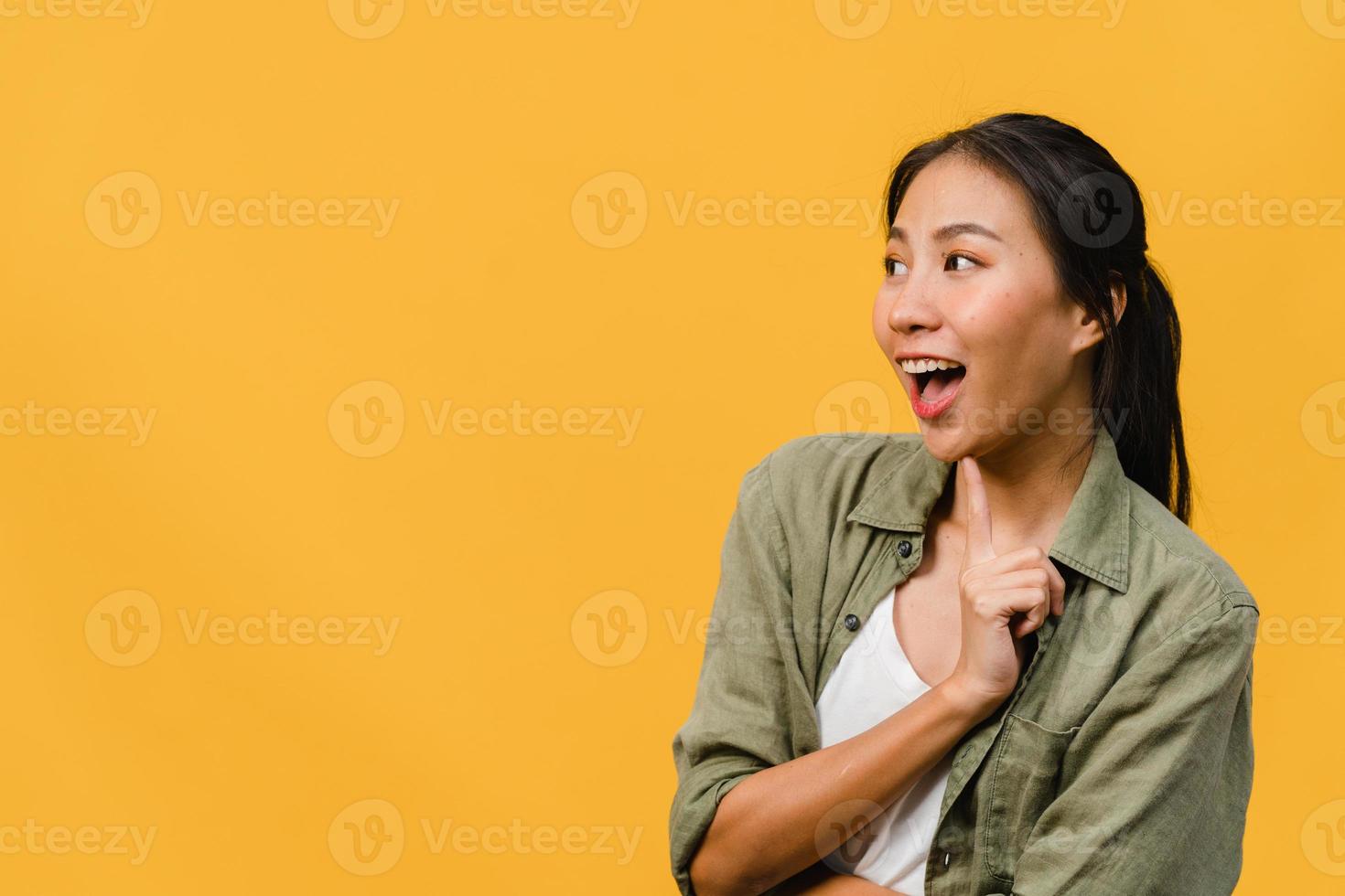 la giovane donna asiatica si sente felice con l'espressione positiva, gioiosa sorpresa funky, vestita con un panno casual isolato su sfondo giallo. felice adorabile donna felice esulta successo. espressione facciale. foto