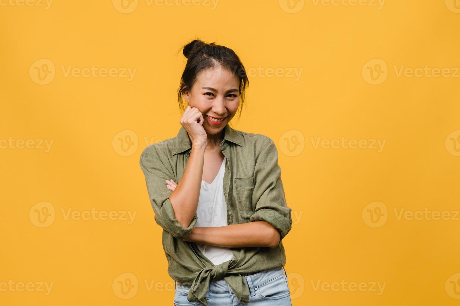 ritratto di giovane donna asiatica con espressione positiva, braccia incrociate, sorriso ampiamente, vestita con abiti casual e guardando la telecamera su sfondo giallo. felice adorabile donna felice esulta successo. foto