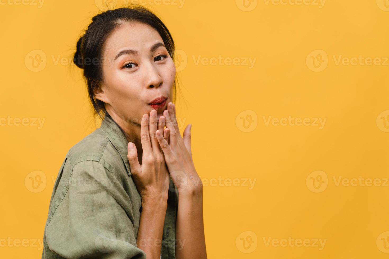 la giovane donna asiatica si sente felice con l'espressione positiva, gioiosa sorpresa funky, vestita con abiti casual e guardando la telecamera isolata su sfondo giallo. felice adorabile donna felice esulta successo. foto