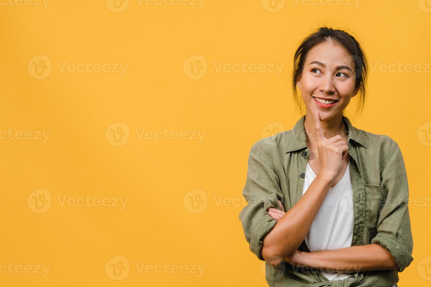 ritratto di giovane donna asiatica con espressione positiva, braccio incrociato, sorriso ampiamente, vestita con un panno casual su sfondo giallo. felice adorabile donna felice esulta successo. concetto di espressione facciale. foto